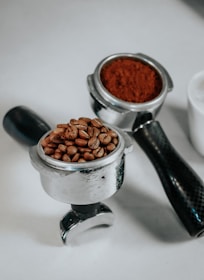 a coffee grinder filled with coffee beans next to a cup of coffee