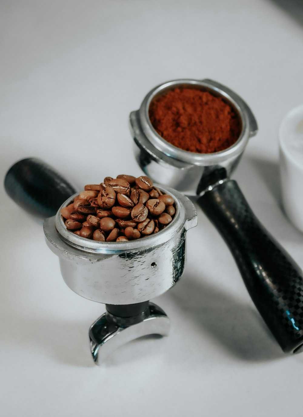 a coffee grinder filled with coffee beans next to a cup of coffee