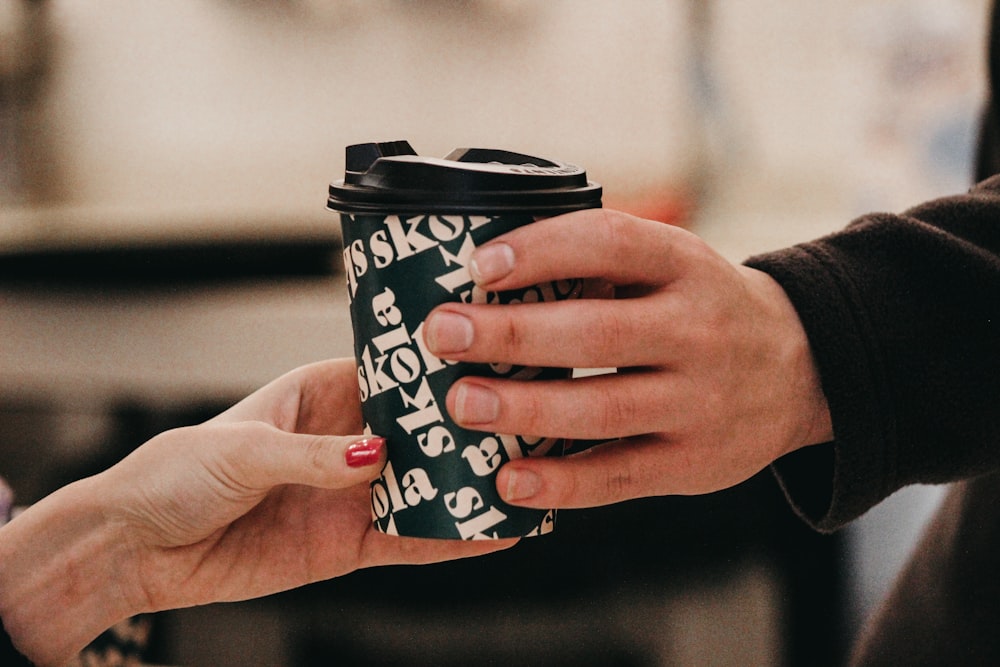 a person handing another person a cup of coffee