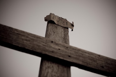 Close-up of a weathered cross carved into wood, representing steadfast devotion.