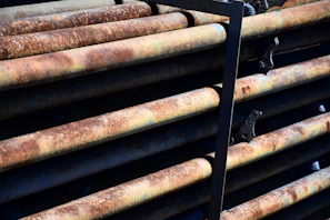 Close-up of industrial metal pipes stacked in a warehouse