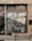A storefront with a large window displays the words 'Smiths Home' and various white line drawings depicting household items and plants. Outside, there is a wooden bench and several potted plants. The building has a tiled facade with various stickers on the door frame.