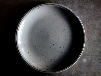 Close-up of a colorful stoneware plate with a rustic, cozy feel on a linen tablecloth.