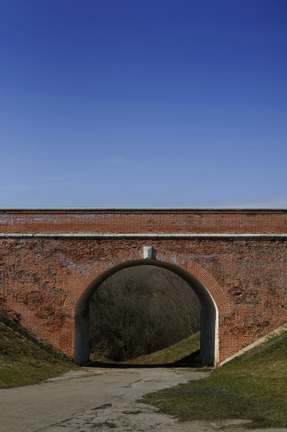 a brick tunnel with a walkway going through it