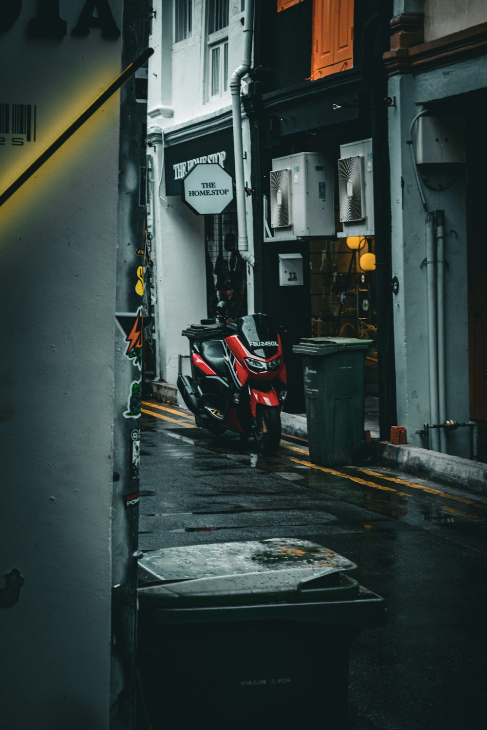 a red scooter parked on the side of a street