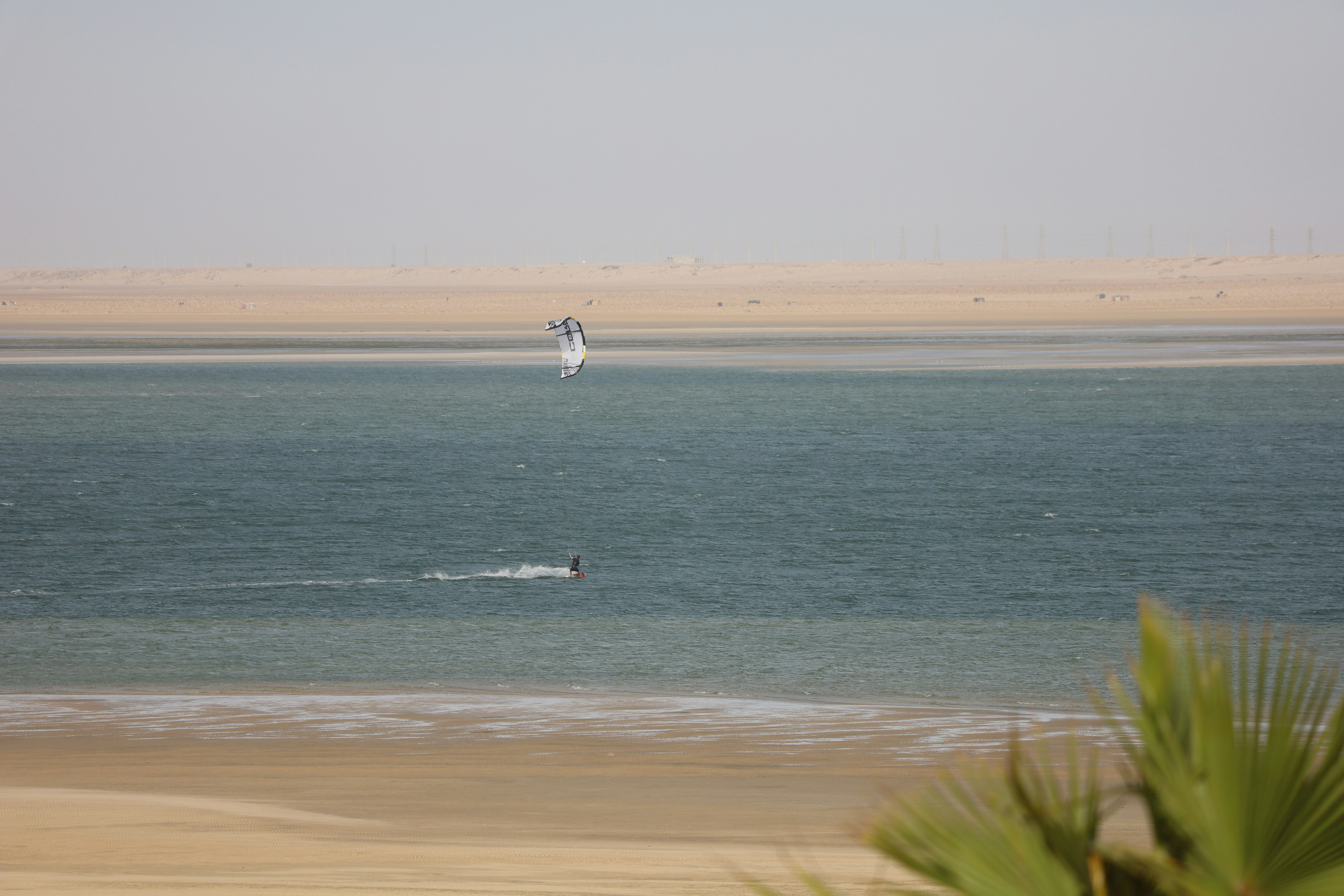 a person windsurfing in the ocean on a sunny day, 