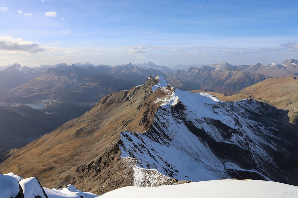 a view of a snowy mountain range from the top of a mountain