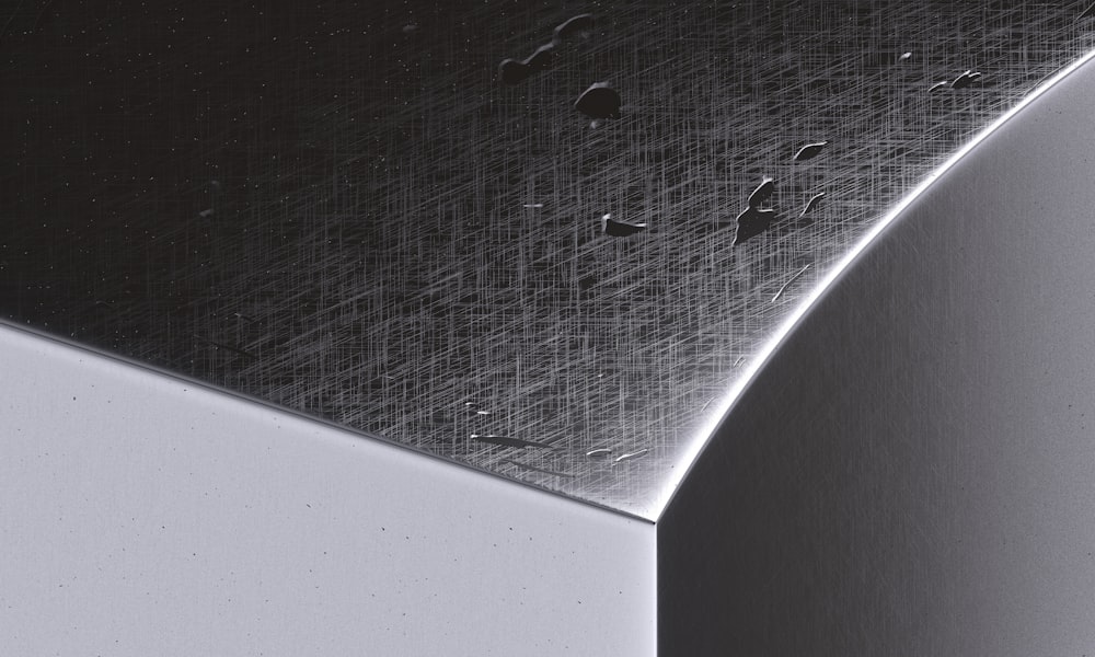 a close up of a metal surface with drops of water on it