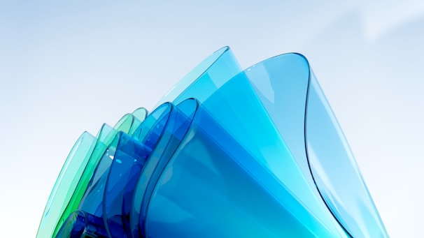 An arrangement of translucent floating shapes in varying shades of blue with subtle reflections