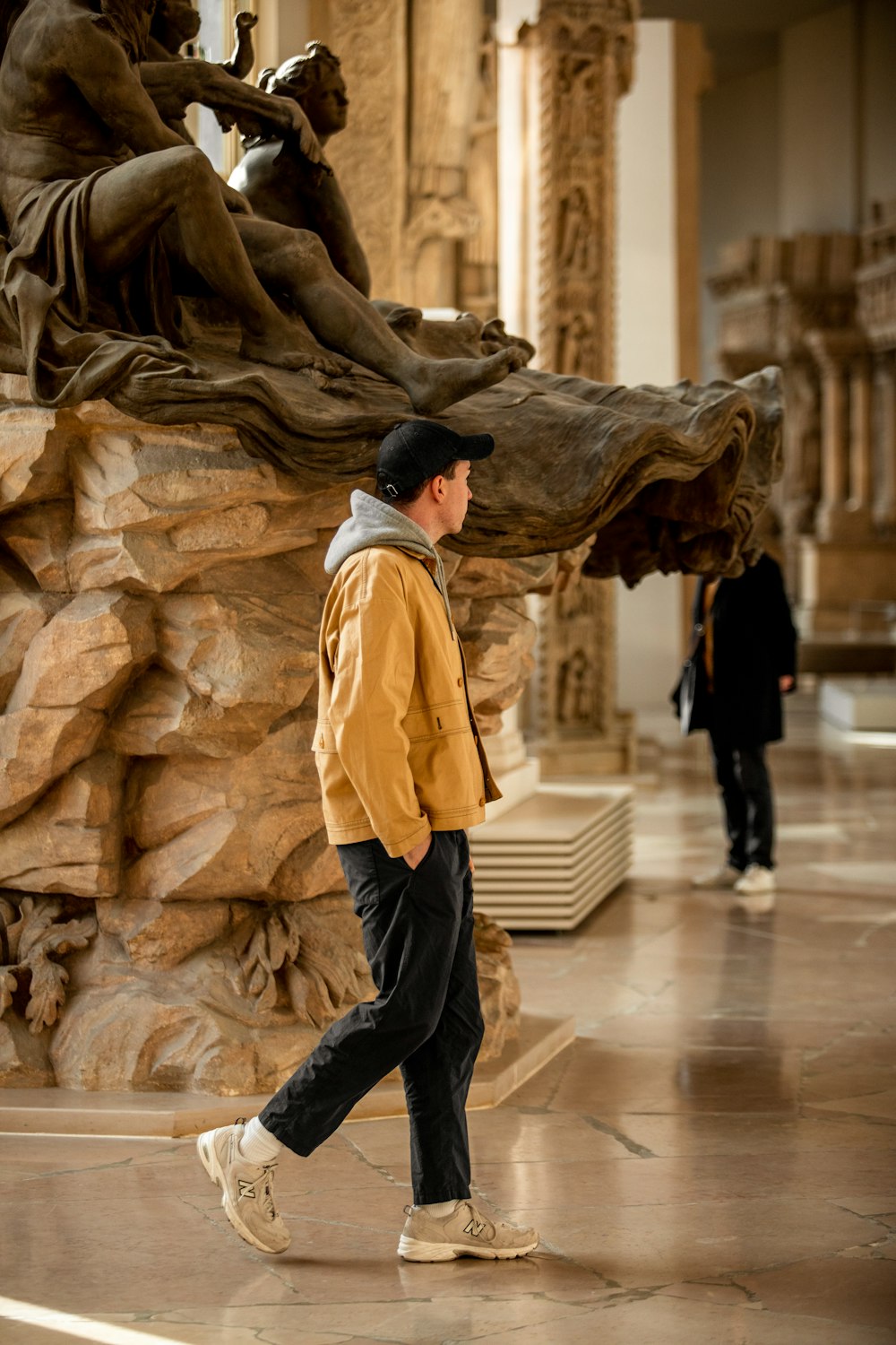 a man walking past a statue in a museum