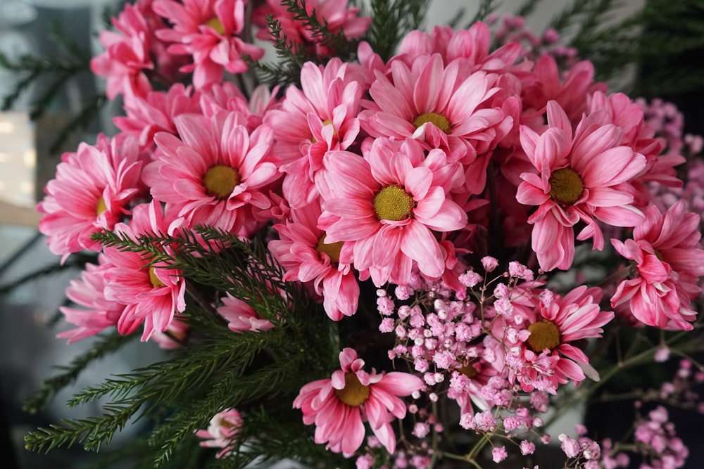 a vase filled with pink flowers on top of a table