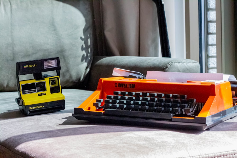 a yellow and black typewriter sitting on top of a couch
