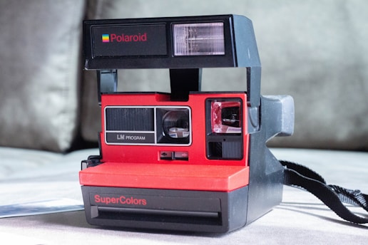 a polaroid camera sitting on top of a bed
