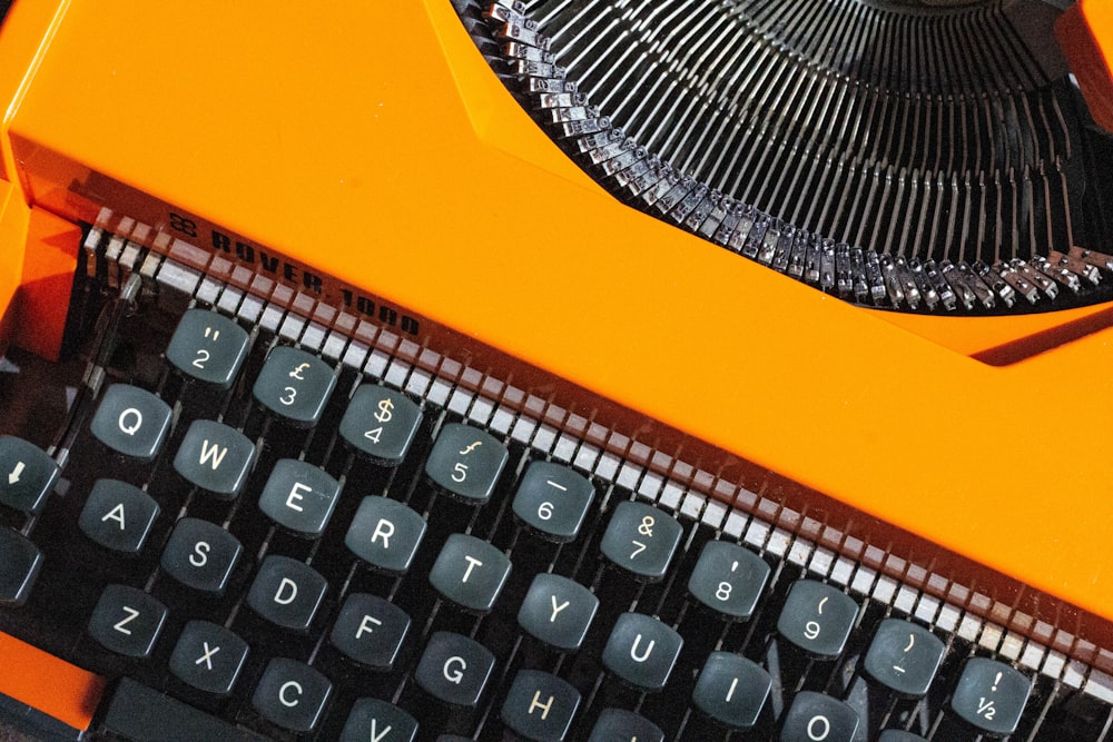 a close up of an orange typewriter