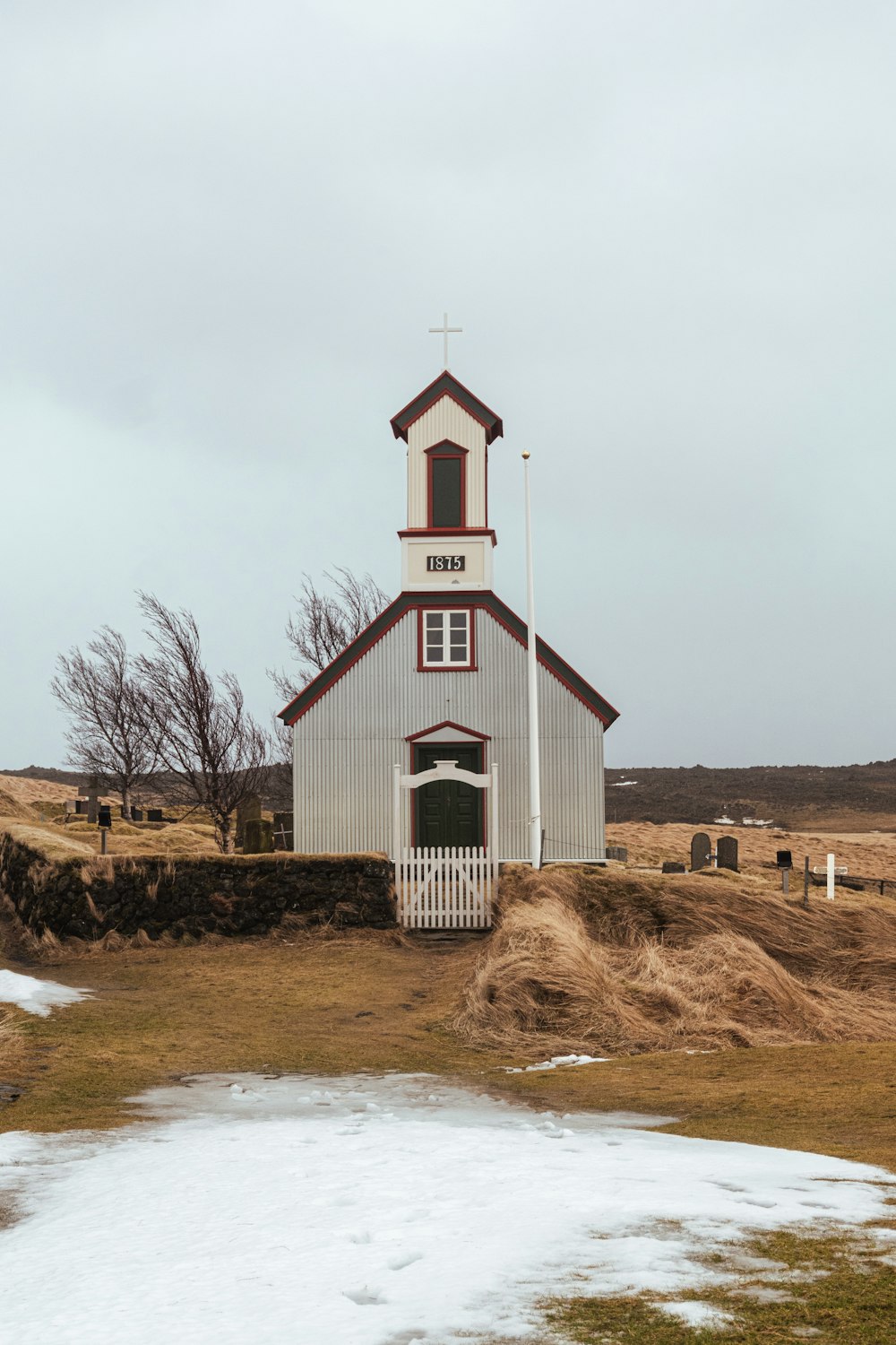 a small white church with a steeple and a cross on top