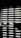 Horizontal blinds partially cover a window, creating a pattern of alternating light and shadow. Below the window, there is a reflective surface, possibly a table, displaying the same pattern along with a few small objects.