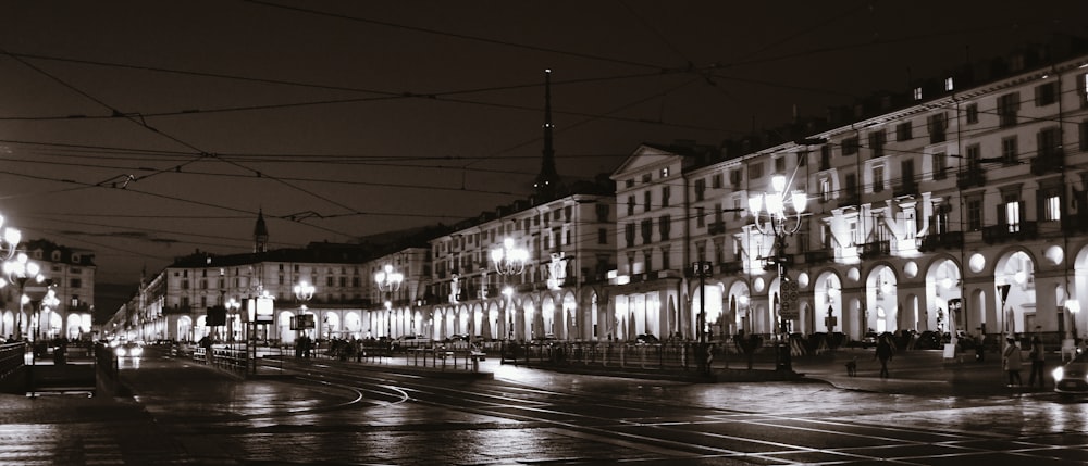 a black and white photo of a city street at night