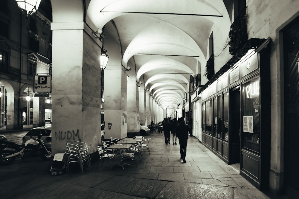 a black and white photo of people walking down a street