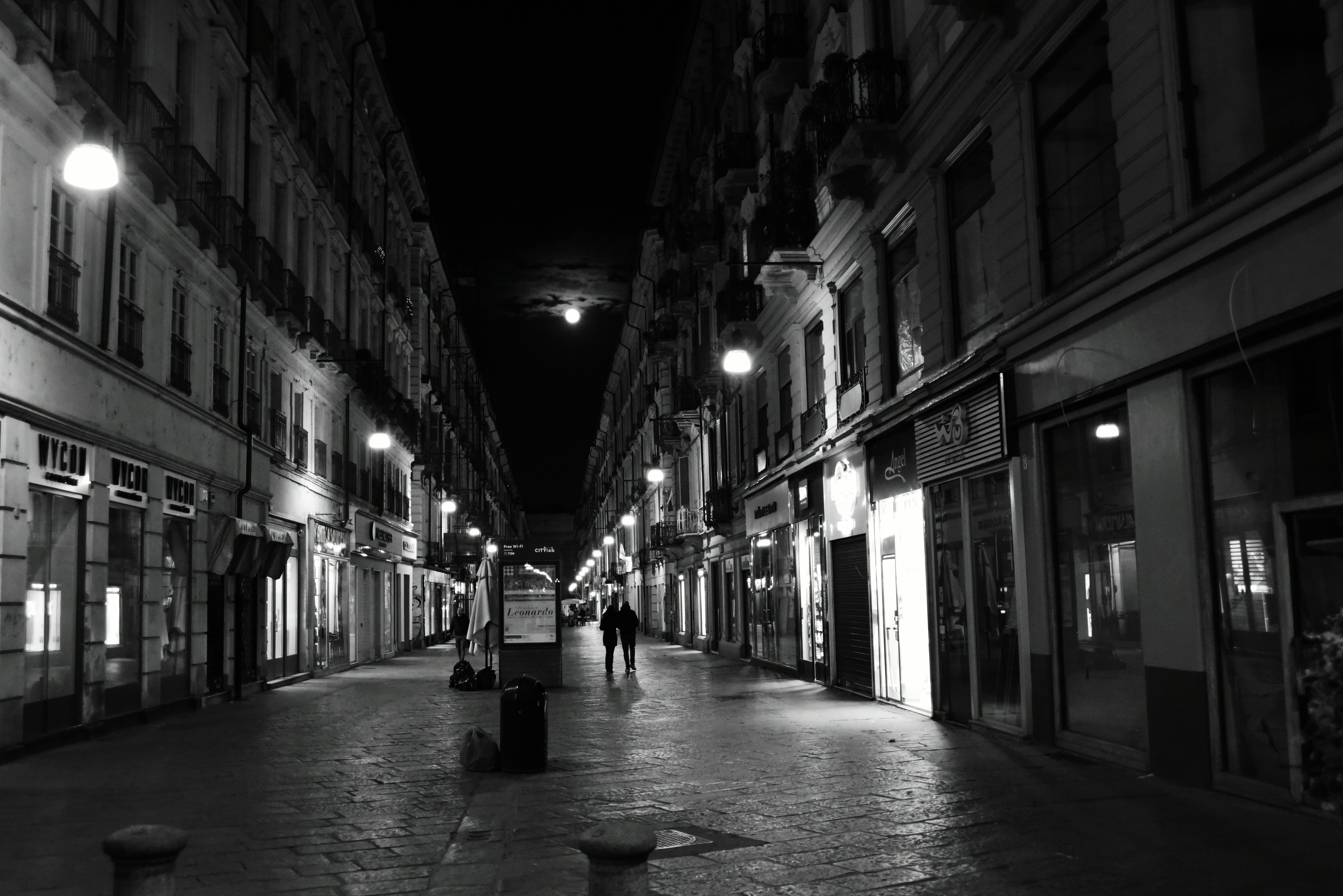 a black and white photo of a street at night, 