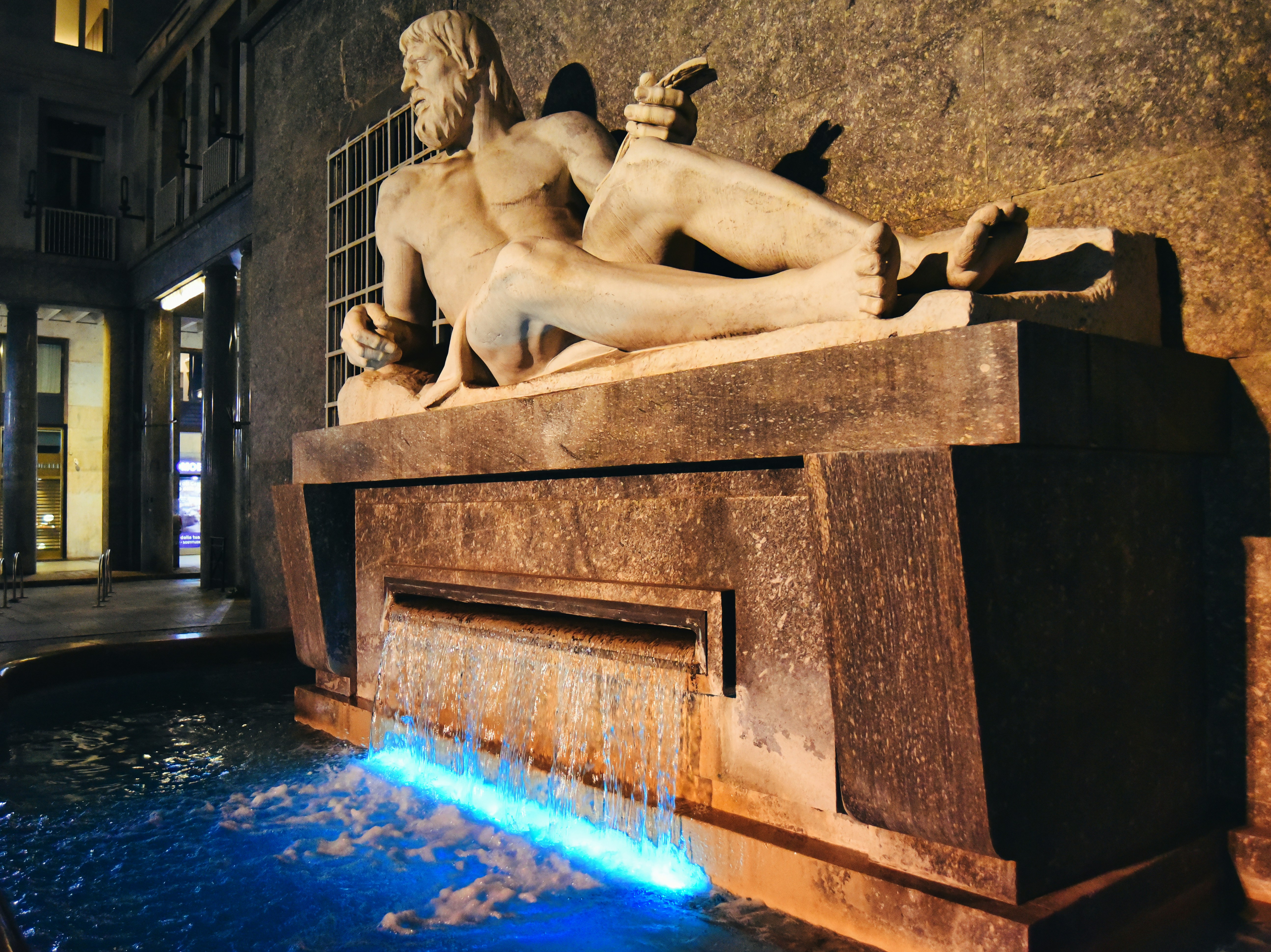 a statue of a man and a woman laying on top of a fountain