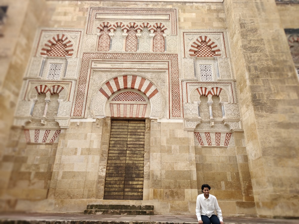 a man sitting on the steps of a building