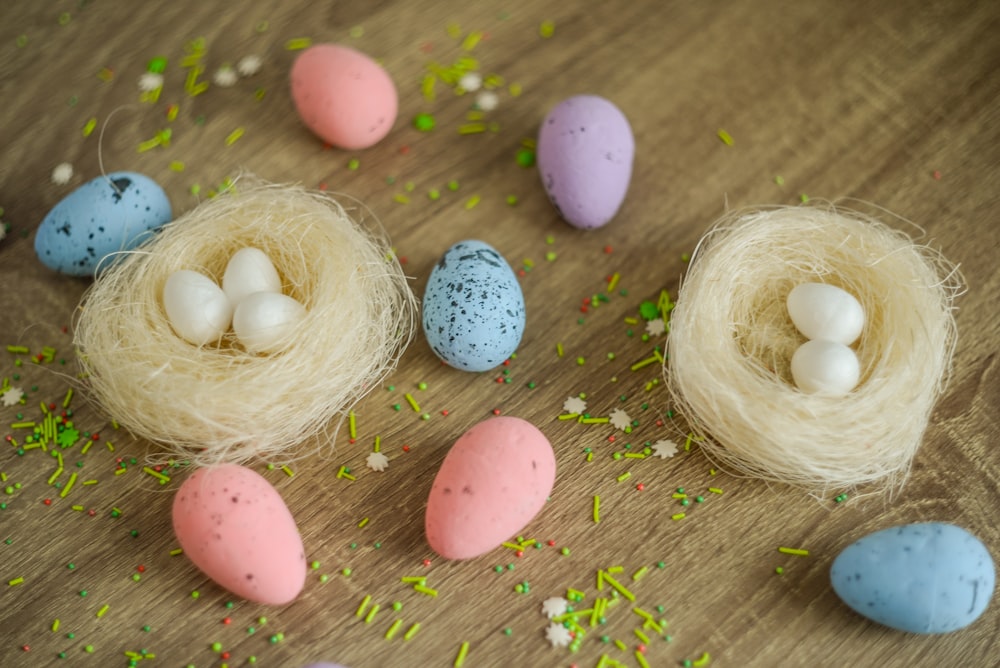 a bird's nest with eggs and sprinkles on a table