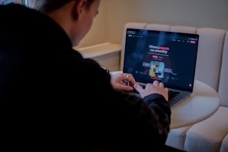 a person sitting at a table with a laptop