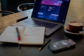 a laptop computer sitting on top of a wooden table