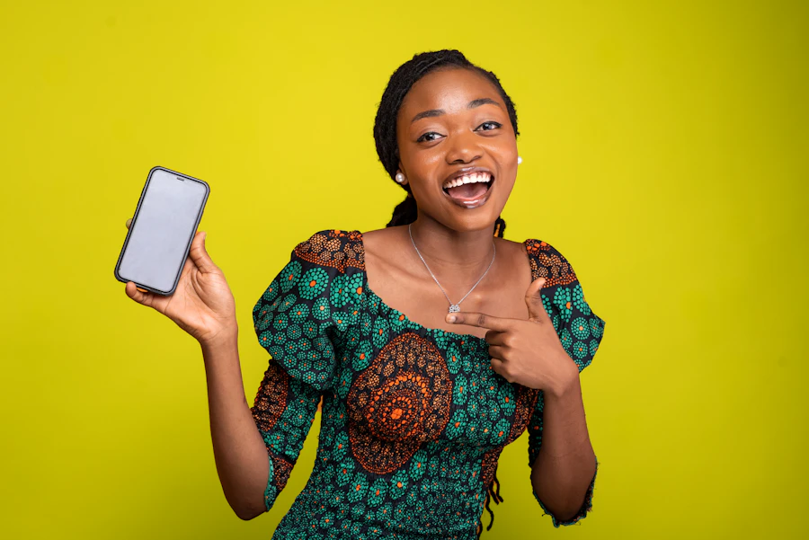 Une maman souriante tient son téléphone, prête à payer les frais scolaires de son enfant