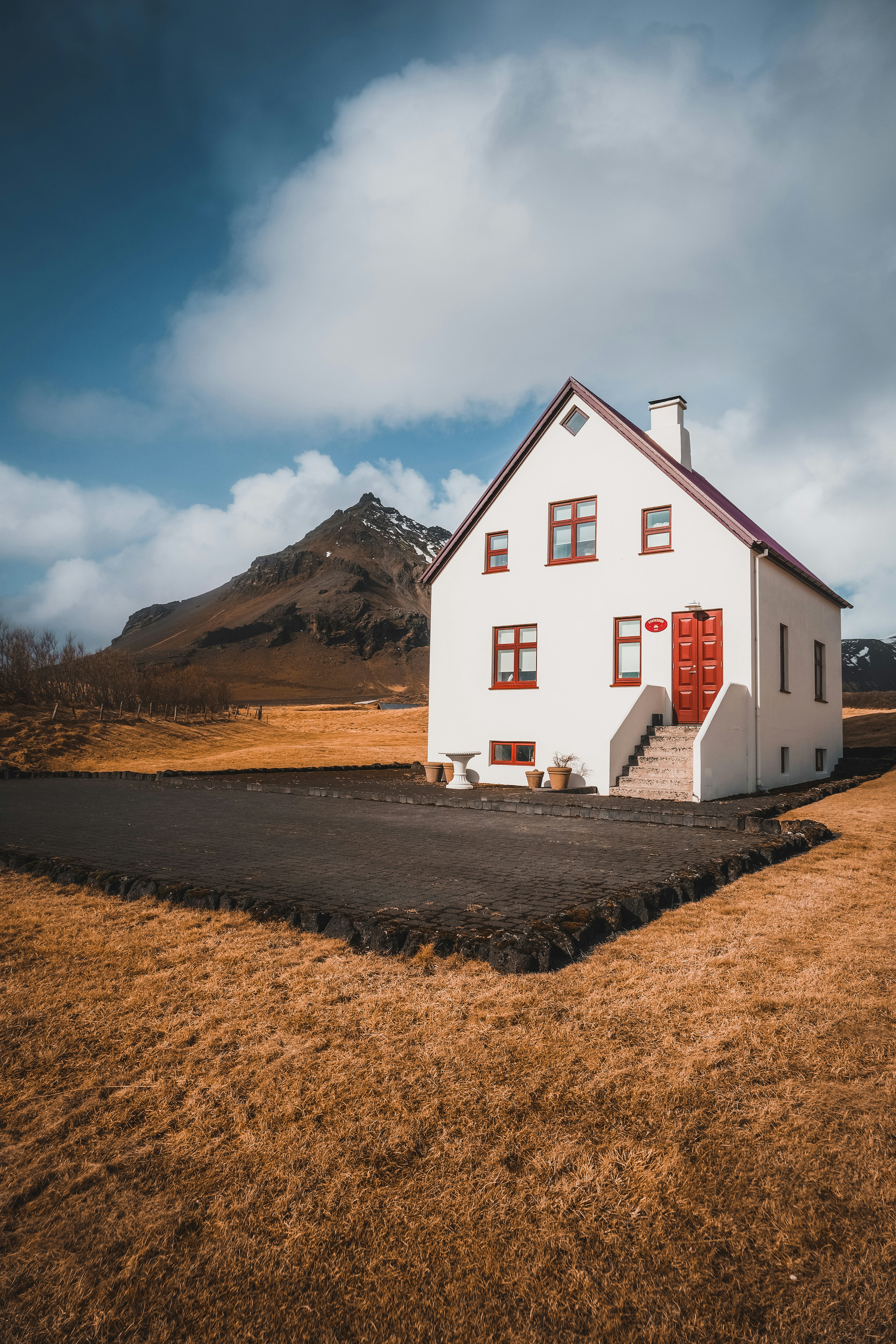 Ein kleines weißes Haus mit einer roten Tür