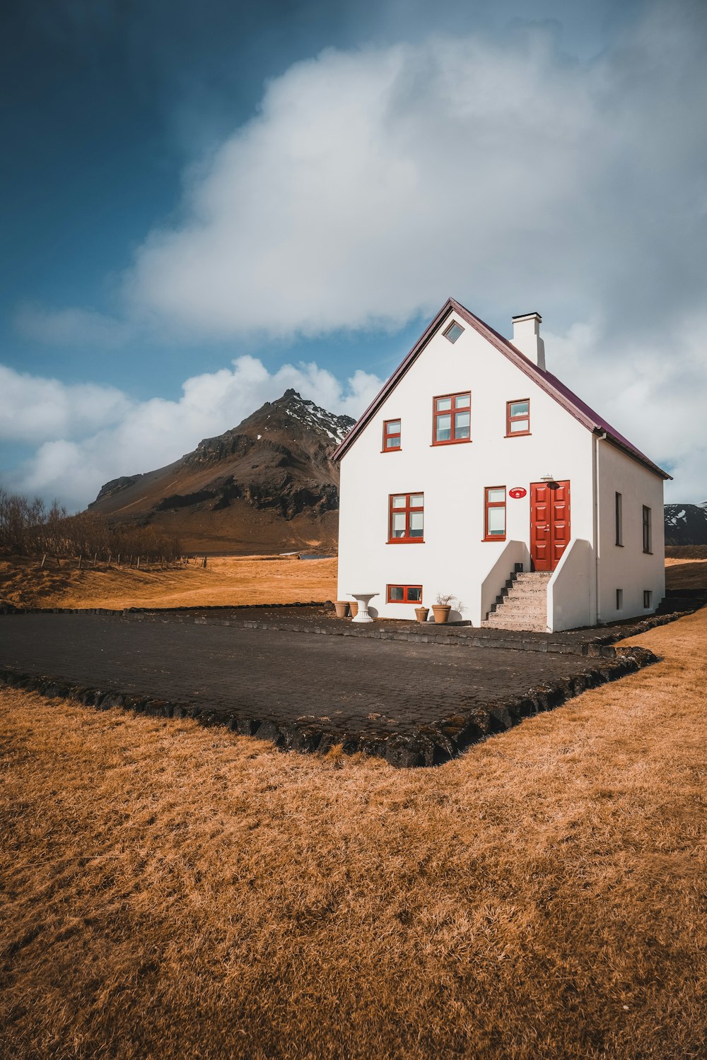 a small white house with a red door