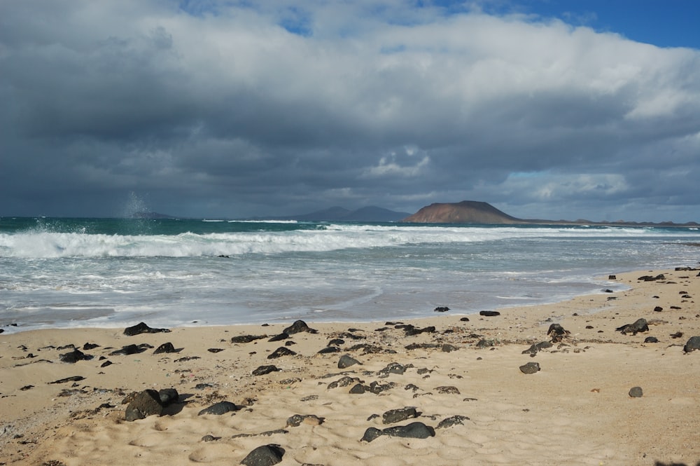 a sandy beach with waves crashing in to shore