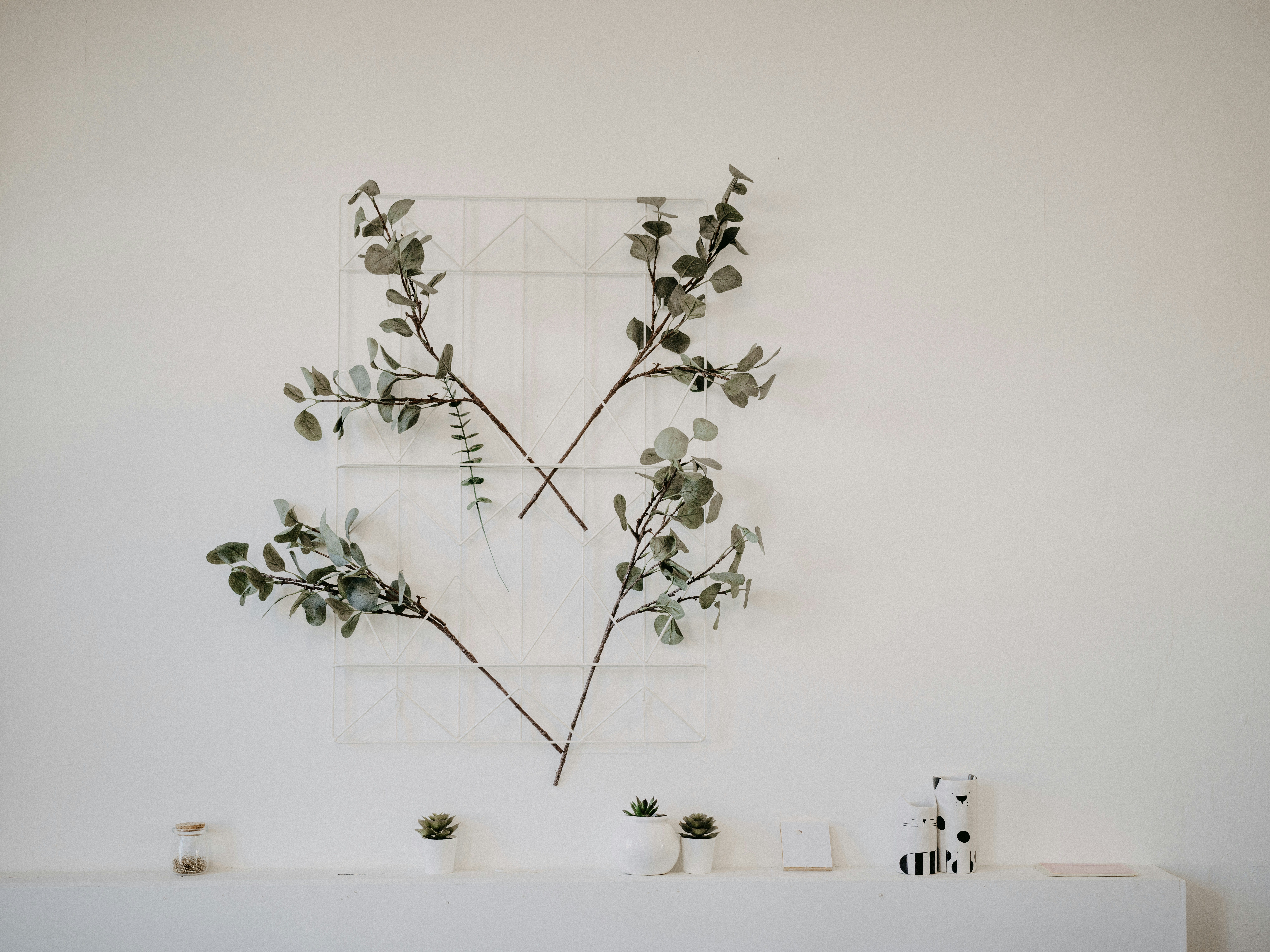 a white fireplace with a plant on top of it