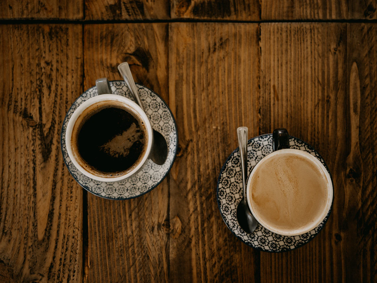 Two cups of coffee on a wooden table