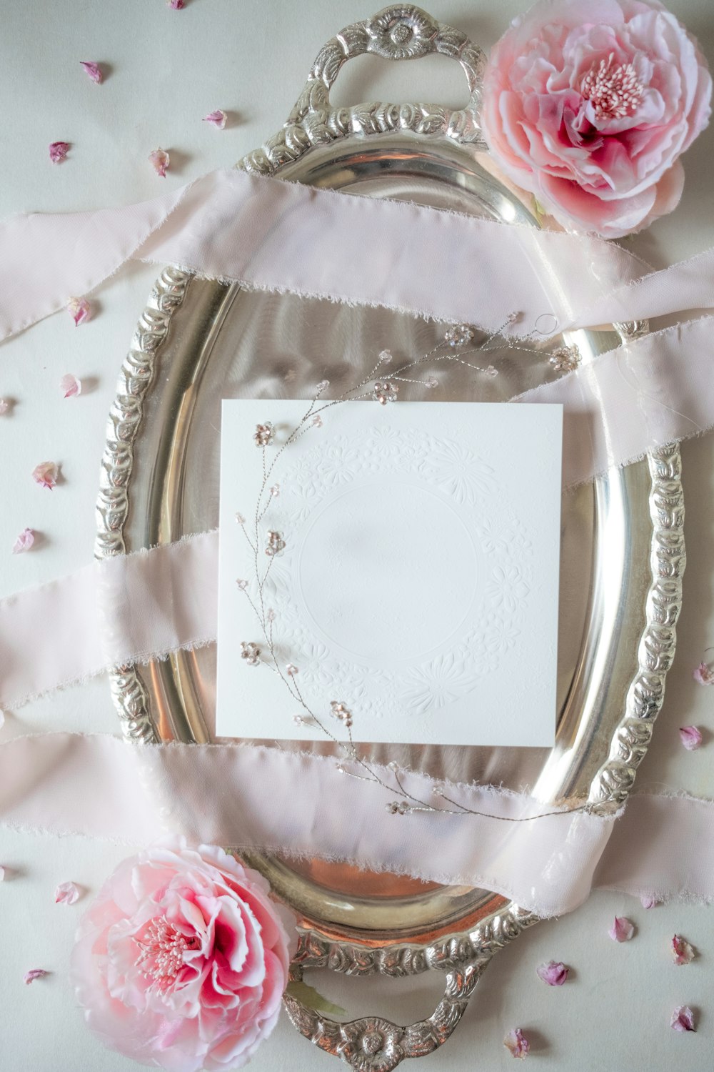 a picture frame with pink flowers and a white card