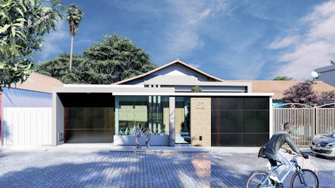 a person riding a bike in front of a house