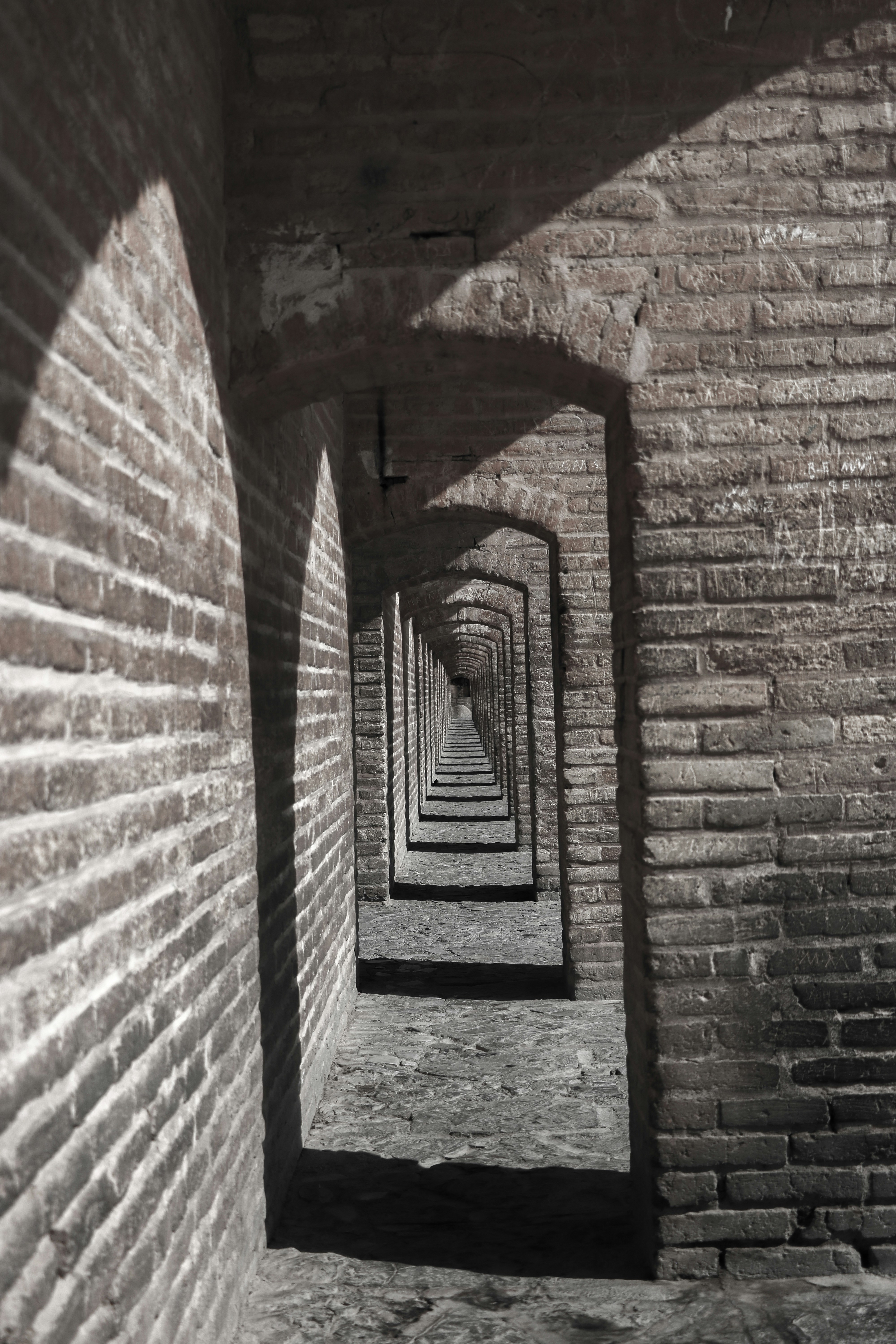 a long brick tunnel with a light at the end