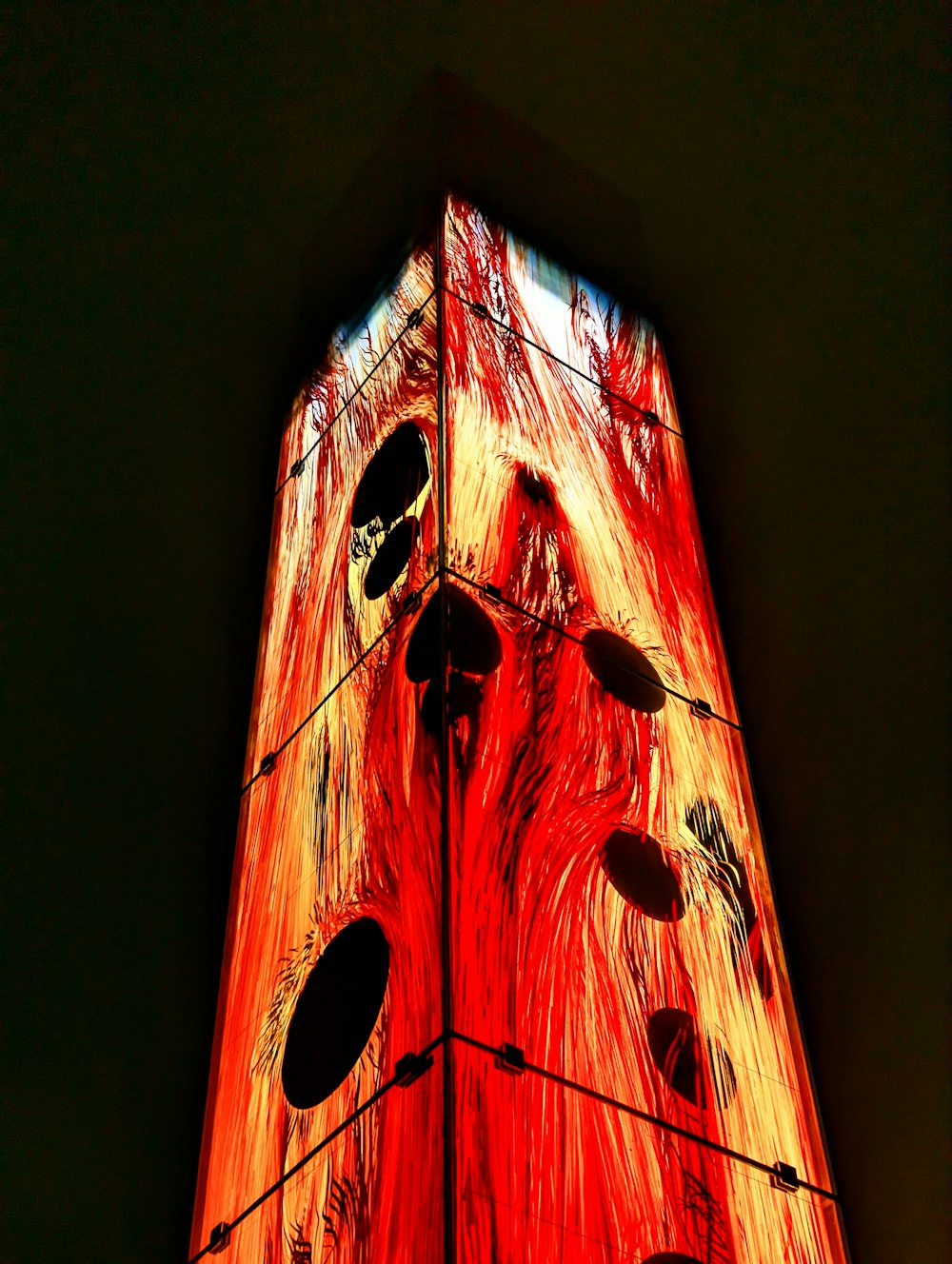 a tall clock tower lit up with a red light