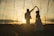 A happy couple dancing at their wedding with a beautiful sunset in the background.