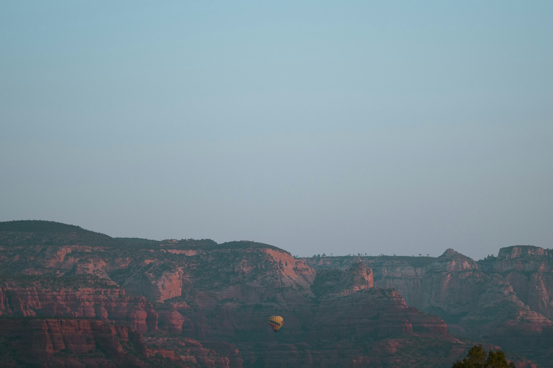 a hot air balloon flying over a mountain range