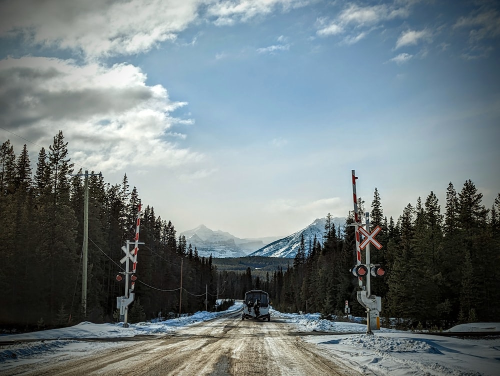 a truck driving down a snow covered road