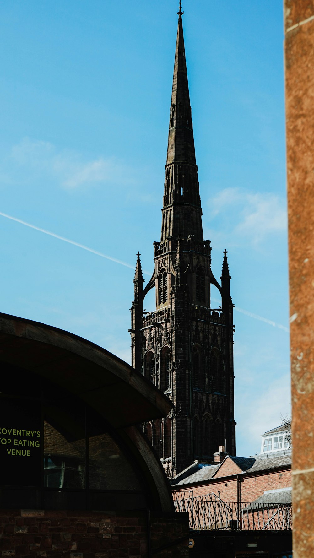 Ein sehr hoher Kirchturm, der über einer Stadt thront