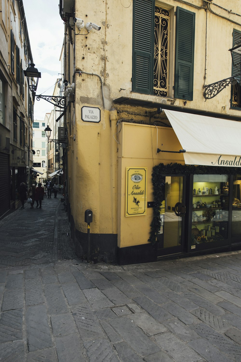 a yellow building with a white awning next to a sidewalk