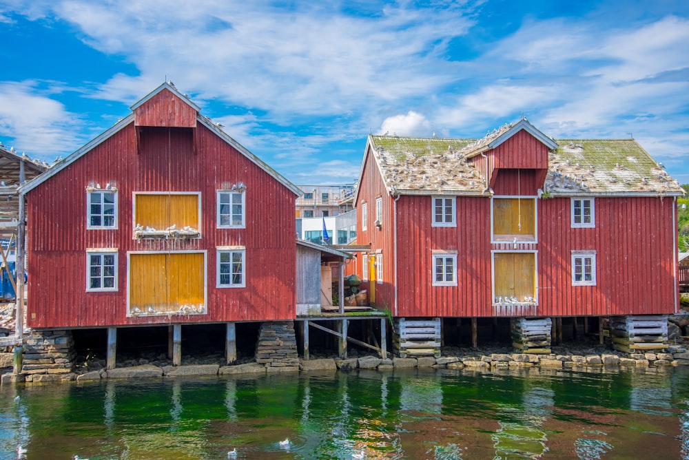 a row of red houses sitting next to a body of water