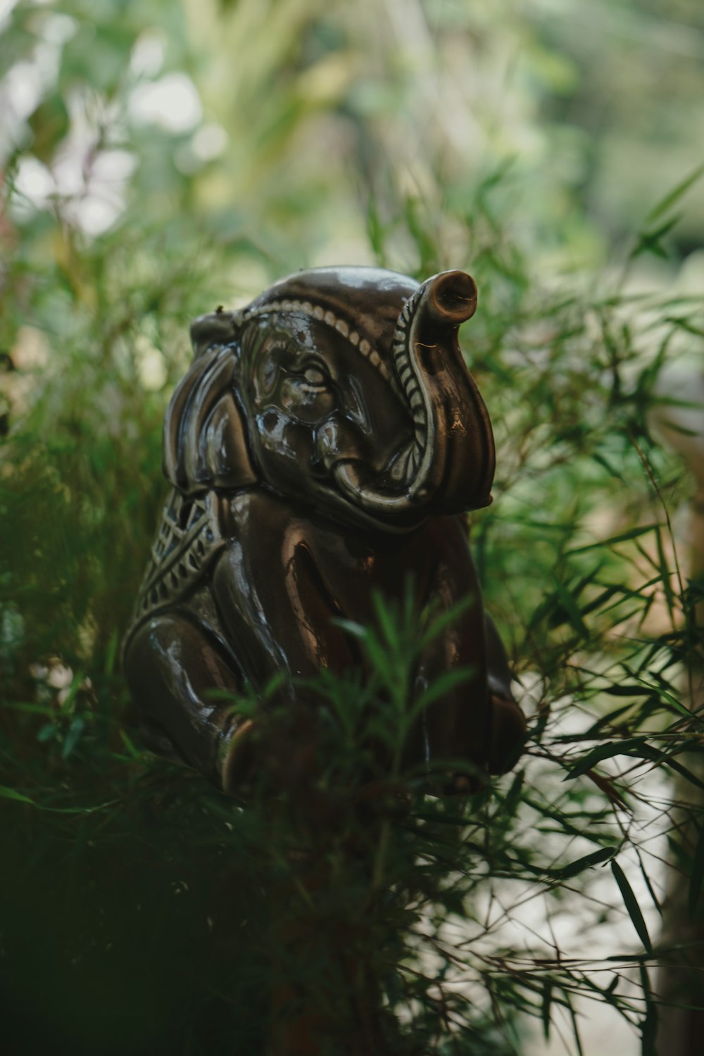 a statue of an elephant sitting in a planter