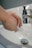 Close-up of hands wiping a kitchen counter with a clean cloth and spray bottle.