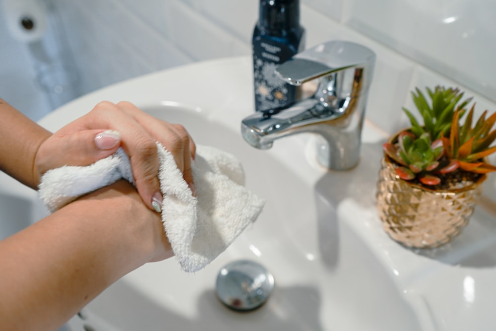 a person wiping their hands with a towel