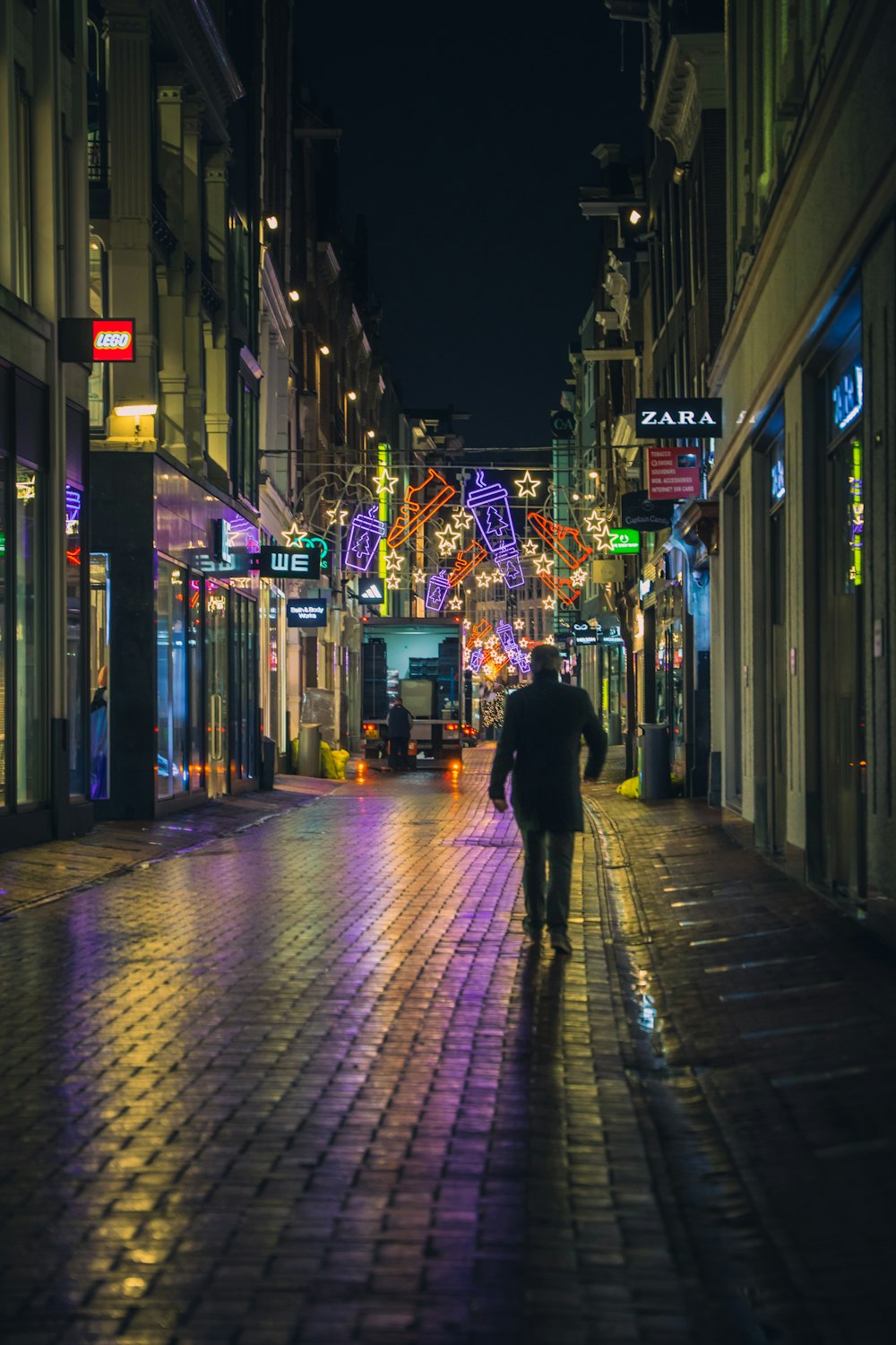 a man walking down a street at night