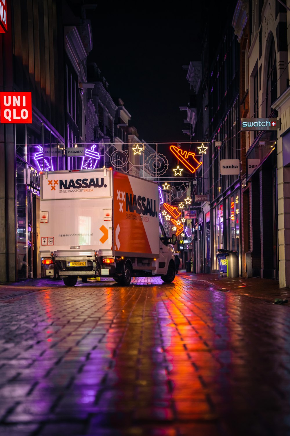 a delivery truck parked on a city street at night