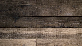 a close up of a wooden wall with a clock on it